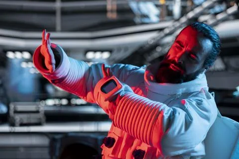 Afraid astronaut protecting himself from alien threat emerging Stock Photos