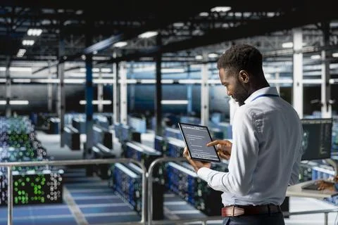 African american admin analyzing infrastructure performance outputs on tablet Stock-Fotos