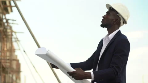 African american architect checking construction site with blueprint outdoors Stock Footage 146443877