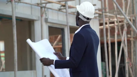 African american architect checking construction site with blueprint outdoors Stock Footage 146444463