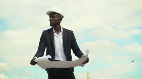 African american architect checking construction site with blueprint outdoors Stock Footage 146444528