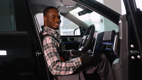 African American auto mechanic using laptop in right-hand car Stock Footage 300611083