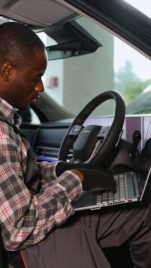African American auto mechanic using laptop in right-hand car Stock Footage 300614520