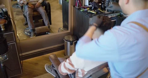 African American barber and client, barber putting on black gloves, combing in Stock Footage 337732034