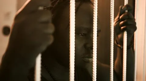 African american black man holding bars in the prison Stock Photos