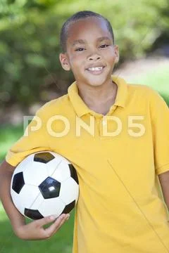 African american boy child playing with football or soccer ball Stock Photos