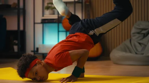 African American boy practicing handstand during breakdance training at home Stock Footage 318545186