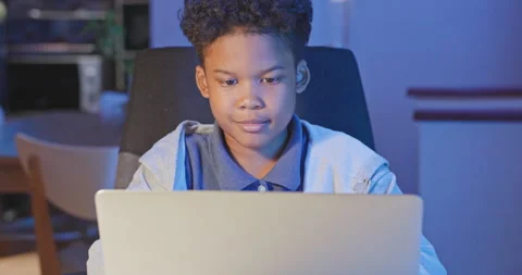 African american boy use computer laptop to studying online at night. Video stock 162125747