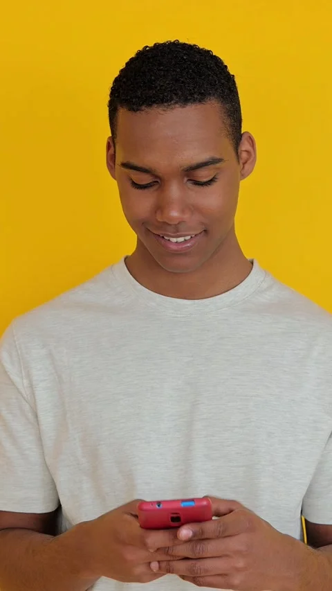 African american boy using mobile phone over yellow background Stock Footage 271324051
