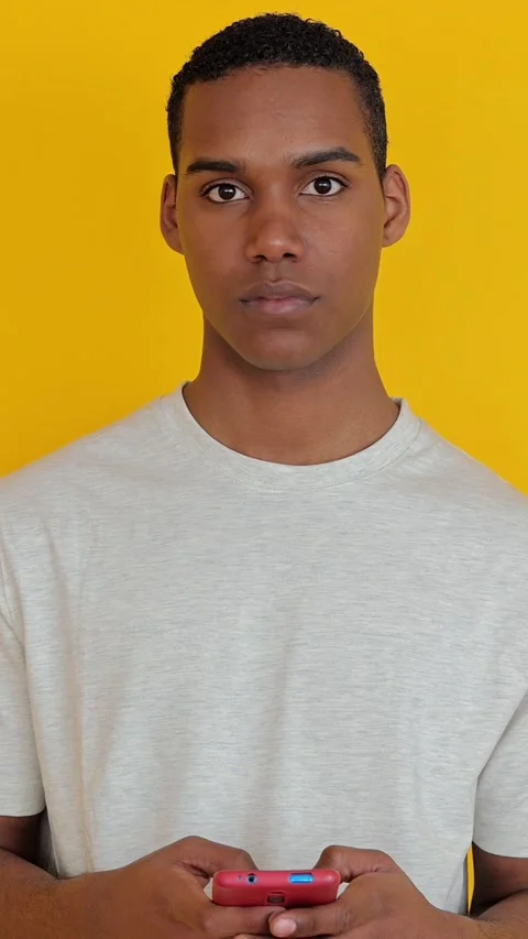 African american boy using mobile phone over yellow background Stock Footage 280364882