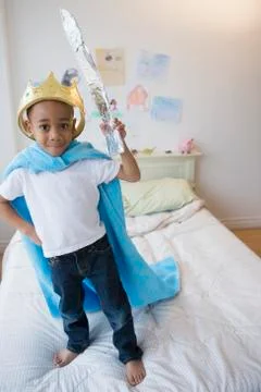African American boy wearing costume on bed Stock Photos