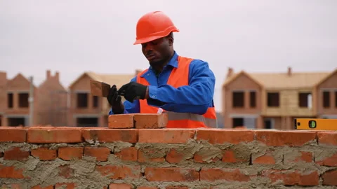 African American builder laying bricks at townhouse construction site Stock Footage 300896206