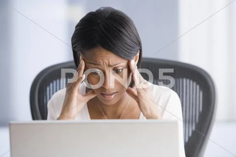 African American businesswoman rubbing temples Stock Photos
