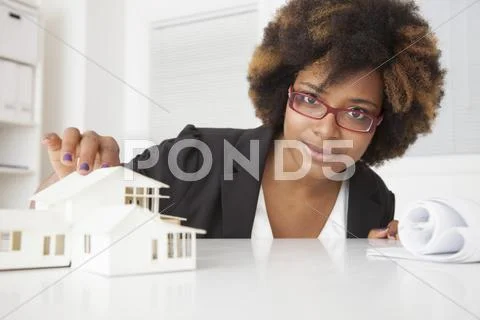 African American businesswoman working on model of house Stock-Fotos