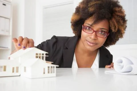 African American businesswoman working on model of house Stock Photos