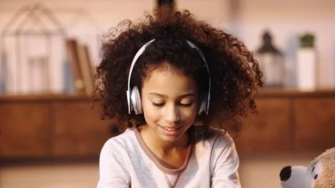 African american child listening music in headphones Stock Footage