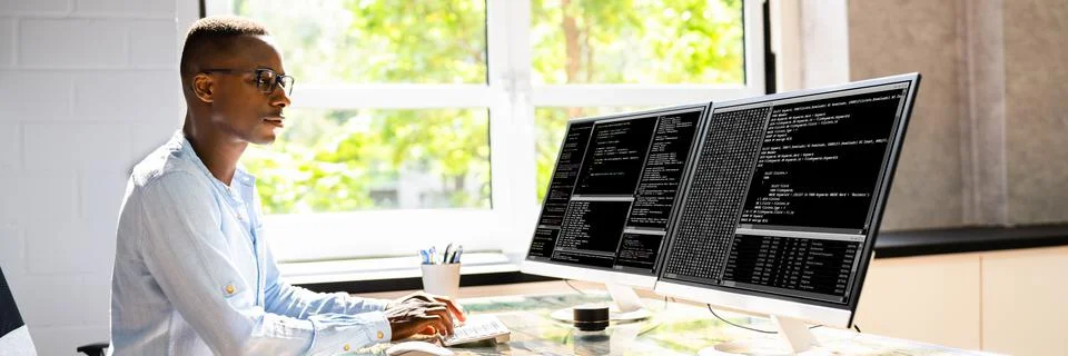 African American Coder Using Computer At Desk 库存照片