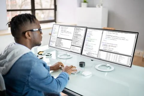 African American Coder Using Computer At Desk 库存照片