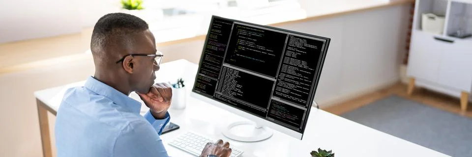 African American Coder Using Computer At Desk 库存照片