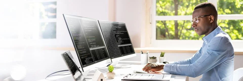 African American Coder Using Computer At Desk Stock-Fotos