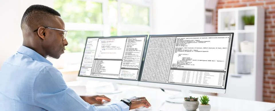 African American Coder Using Computer At Desk Stock-Fotos