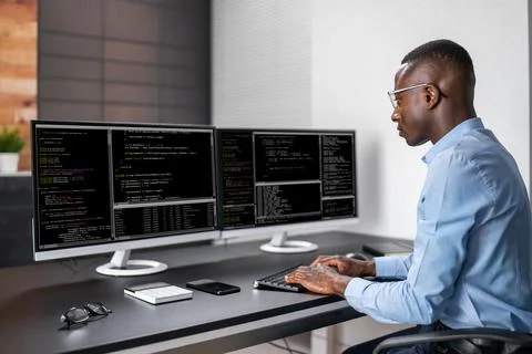 African American Coder Using Computer At Desk Stock-Fotos