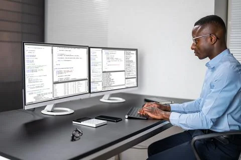 African American Coder Using Computer At Desk Stock-Fotos