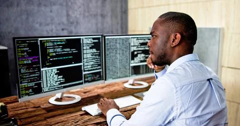 African American Coder Using Computer At Desk Stock-Fotos