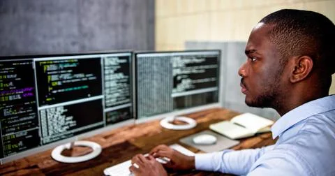 African American Coder Using Computer At Desk Stock-Fotos