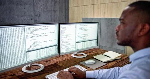 African American Coder Using Computer At Desk 库存照片