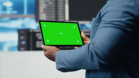 African american coder works on a script with green screen on tablet Stock Footage 312301338