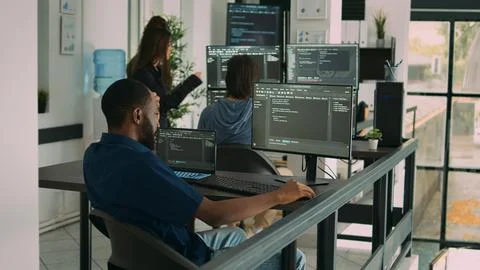 African american coder writing programming language on computer Stock Photos