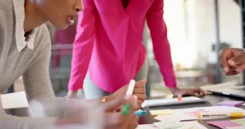 African american colleagues with documents and graphs on table discussing work, Stock Footage 336436258