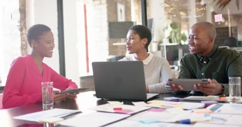 African american colleagues with documents on table using laptop in office, slow Stock Footage 339160755