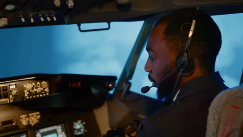 African american copilot using airplane command to fly plane Stock Footage 199572307