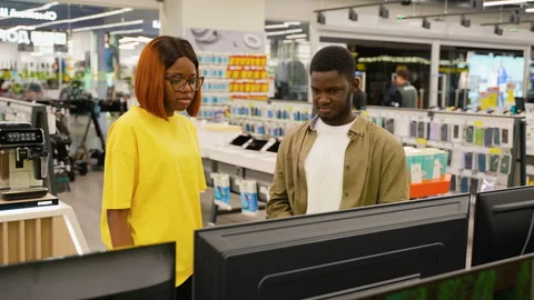 African American couple arguing while choosing a new TV Stock Footage 301730372