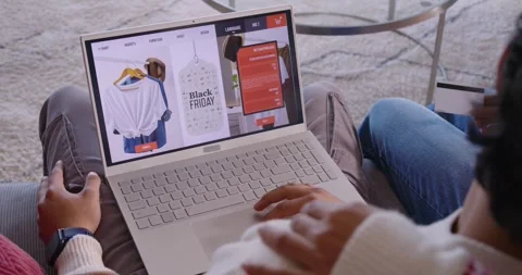 African American couple browsing Black Friday tag on couch with laptop woman Stock Footage 345588409