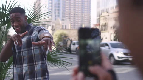 African American couple in the city taking cell phone pictures of each other Stock Footage