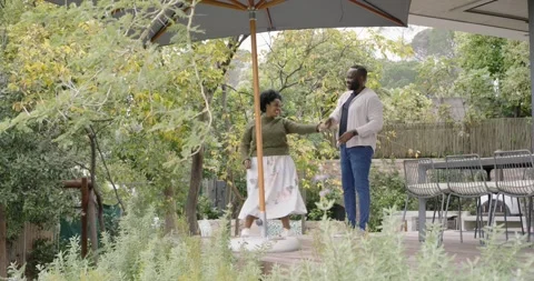 African American couple dancing on deck, woman pulling man, twirling under Stock Footage 337261631