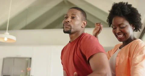 African American couple dancing in kitchen after man tapping counter rhythm Stock Footage 342233257