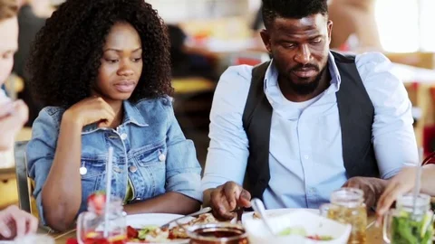 African american couple eating food at restaurant Stock Footage