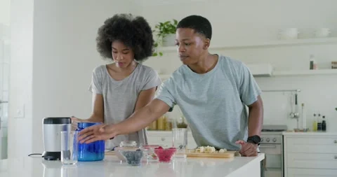 African American couple facing, scooping from blue container and preparing Stock Footage 341320712