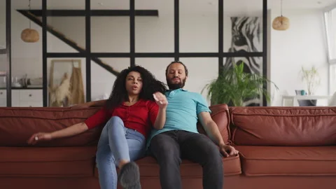 African American couple falling onto a couch, feeling tired after a long workday Stock Footage 333781877