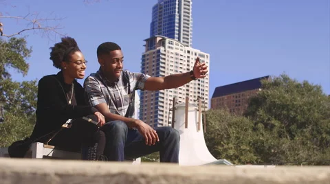 African American couple in front of city high rises, taking picture together Stock Footage