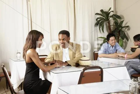 African American couple holding hands at table Stock Photos