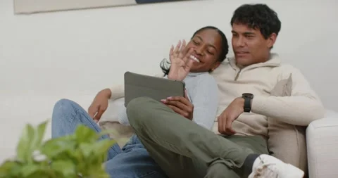 African American couple responding to tablet prompt, tapping screen and laughing Stock Footage 346644511