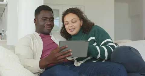 African American couple on sofa, tablet drawing focus, man holding, woman Stock Footage 342065629