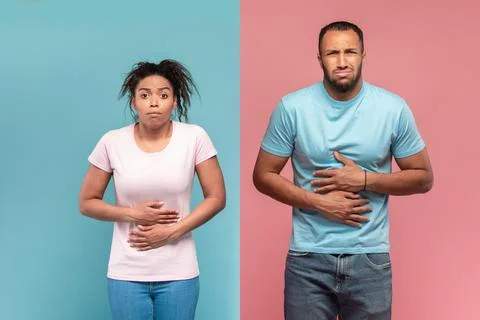 African american couple standing with hand on stomach because indigestion Stock Photos