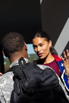 African American couple talking under column, soldier wearing camo backpack, Stock Photos