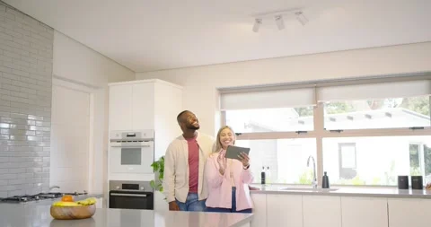 African American couple tapping tablet activating LED strip at kitchen island Stock Footage 342023567
